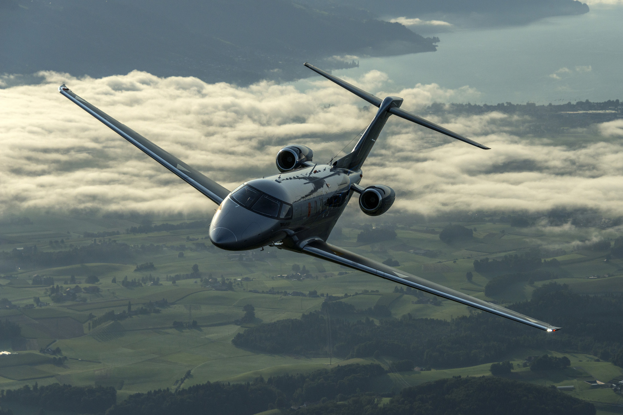 Otter Air Services PC24 Jet flying over grass hills